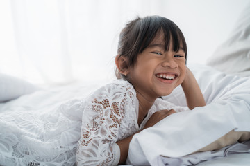 beautiful asian girl kid lying on bed wearing white