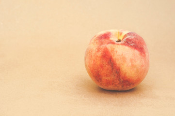Bright fresh peach on a yellow beige background. Sweet juicy peach. Close. Space