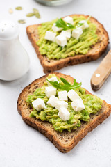 Two slices of bread with mashed avocado and feta cheese. Toast with avocado and cheese. Healthy food