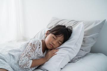 beautiful asian girl kid lying on bed wearing white