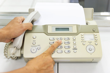 hand man are using a fax machine in the office, equipment for data transmission.