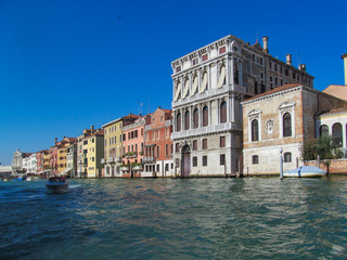 Fototapeta na wymiar Grand Canal in Venice (Italy). Scenic view on famous Venetian landmarks - water surface and seafront with buildings and architecture attractions. 
