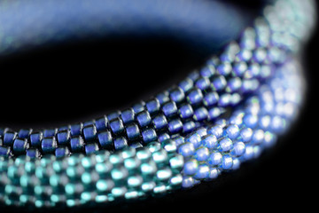 Fragment of a blue beaded necklace on a dark background close up