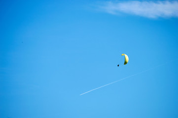 skydiver in the blue sky with clouds and plane on the background