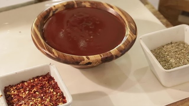 tamarind soup in wooden bowl with mirch powder and dal on the table