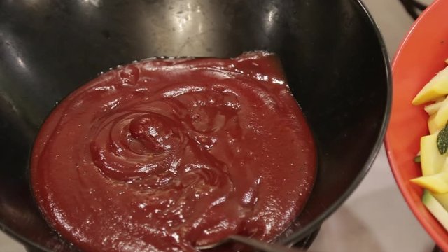 Red tomato sauce isolated in black pan