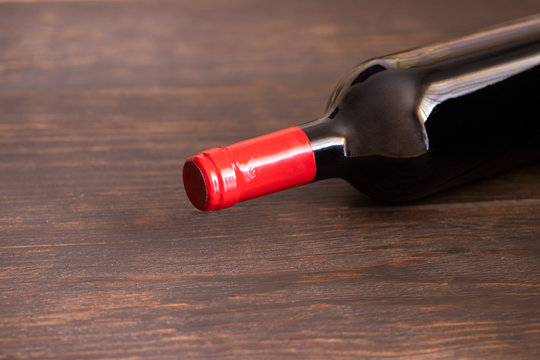 Red wine bottle on wooden background. Wine lovers concept .