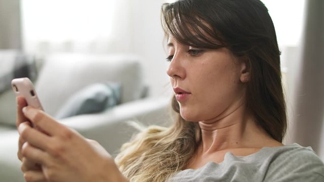Young girl with a phone on the sofa in the living room