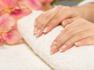 Woman gets manicure procedure in a spa salon. Beautiful female hands.