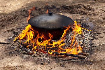 Tourist cauldron on fire. Process of cooking in the forest, outdoor activities.
