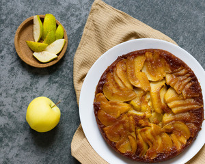 Pear pie on a gray stone. Homemade cake. Gray background. Delicious dessert on a white plate. Food photography. Flan