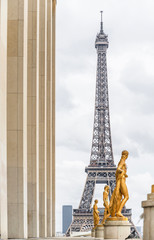 The Eiffel Tower on the background of series of bronze sculptures on pedestals and columns