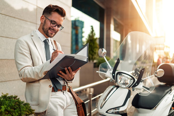 Portrait of businessman holding documents outdoors