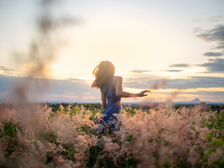 Beauty Girl Outdoors enjoying nature. Beautiful Teenage Model girl in the Spring Field, Sun shine.