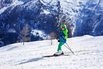 Fototapeta na wymiar Little skier having fun riding down the slope