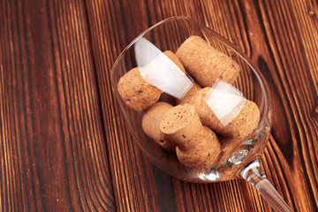 glass of wine with cork on wooden background.