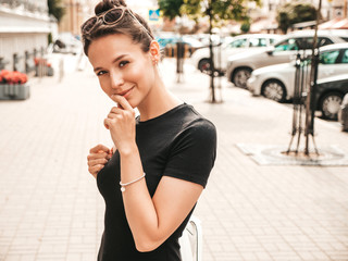 Portrait of beautiful smiling hipster model dressed in summer clothes. Trendy girl posing in the street background. Funny and positive woman having fun