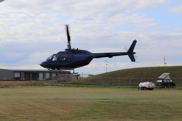 Fototapeta na wymiar Helicopter Takes Off By Wind Turbine