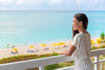 Resort vacation happy Asian woman tourist enjoying ocean view from beach front hotel room on...