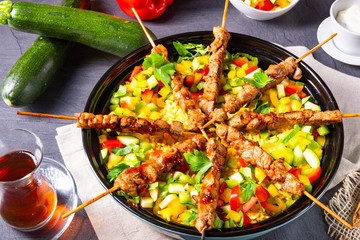 Lamb skewers with curry rice and different vegetables