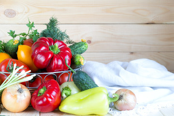 New harvest background with copy space. Fresh vegetables in wicker basket on wooden table.