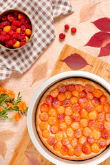 Homemade delicious sweet apricot pie served with raspberries on a table, top view