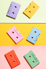 Painted audio cassettes on bright multicolor background, copy space, top view. Retro musical background