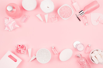 Gentle soft pink cosmetic set for body and skin care, makeup - cream, soap, essential oil, cotton pad, sponges, jewelry, gift box, bath salt, towel on pastel pink color, copy space.