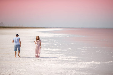 Fototapeta na wymiar A guy looks at a girl on a pink lake.