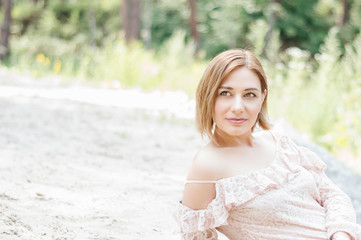 portrait of a girl in a lace dress in nature, looking away