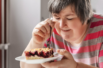 Frau mit geistiger Behinderung isst einen Kuchen, Ernährung und Alltag