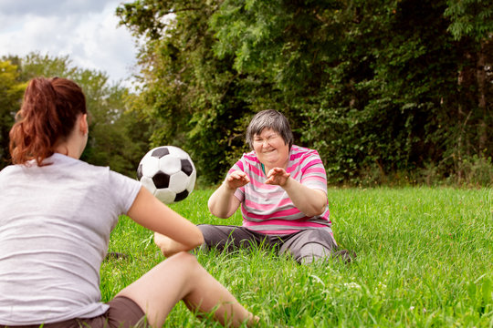 Zwei geistig behinderte Frauen werfen sich einen Ball zu, Übungen für Koordination und Konzentration