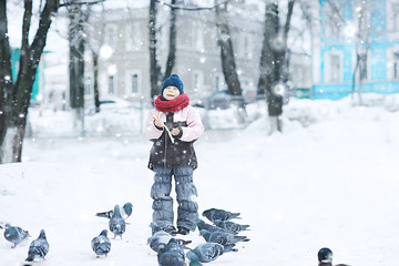 Fototapeta na wymiar girl in winter for a walk in the park / seasonal photo of a child in warm clothes. Winter landscape with a child. Walk frost, urban style, upbringing,, christmas vacation