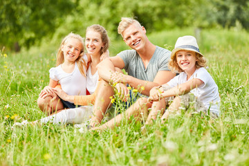 Glückliche Familie sitzt entspannt im Gras