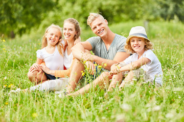 Fototapeta premium Glückliche Familie sitzt entspannt im Gras