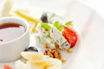 Gourmet, restaurant, delicious dinner food - close up of cheese plate with honey dip and fresh berries
