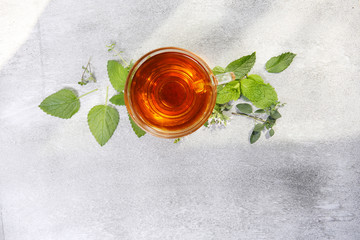 cup of hot herbal tea with mint, lemon balm and oregano flowers