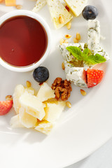 Gourmet, restaurant, delicious dinner food - close up of cheese plate with honey dip and fresh berries