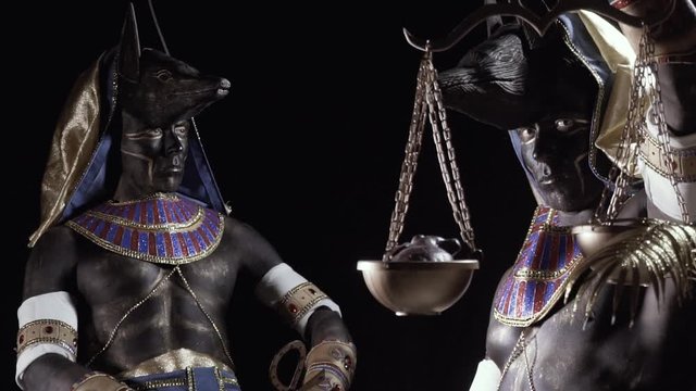 Anubis is sitting in a dark room and close up of Anubis with golden scales