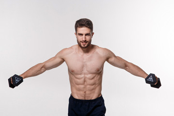 Young athlete on a white background lifts dumbbells. training a bearded man athletic build