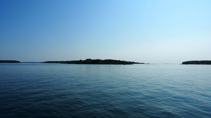 Landschaft am Meer mit 3 Inseln am Horizont