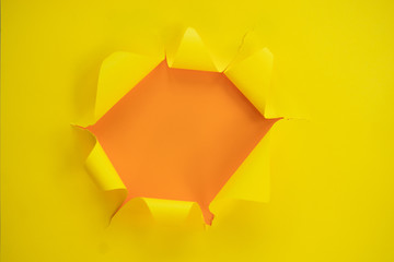 ripped yellow paper against a orange background