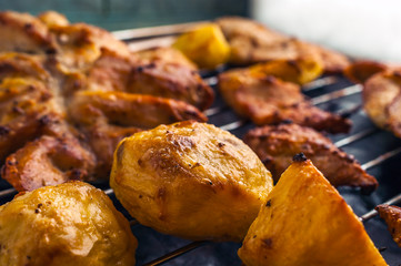 Roasted Potatoes and Chicken Slices on Stainless Steel Cooking Grid.