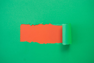 ripped green paper against a red background