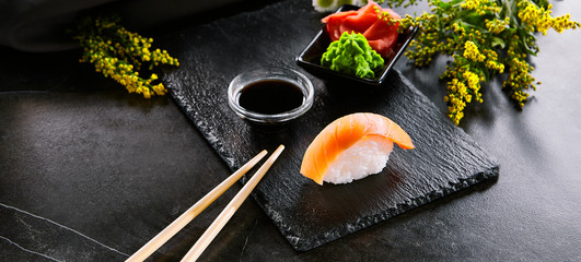 Obraz na płótnie Canvas Delicious seafood, sushi with salmon closeup. Traditional japanese cuisine restaurant menu item. Oriental culinary, eastern food. Appetizer with natural raw fish fillet and sauce on wooden platter