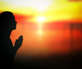 Forgive concept: Silhouette prayer woman pray to God on autumn sunset background