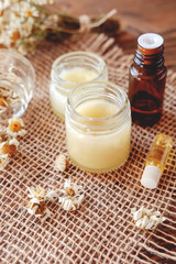 Fototapeta na wymiar Hand cream and lip balm in a glass jar. Natural organic cosmetics with honey, wax and oils.