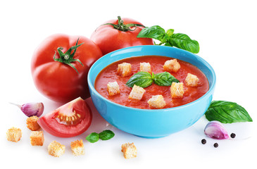Bowl of tomato soup, tomatoes, croutons, garlic and basil  isolated on a white background.