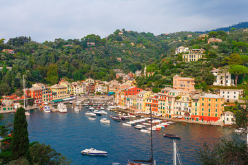 Fototapeta na wymiar Sea landscape in Portofino, Liguria, Italy. Scenic fishing village with traditional houses and clear blue water. Summer vacation luxury rich resort with picturesque harbour and celebrity visitors