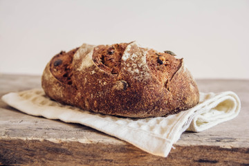 Brown fresh bread with seeds on old wood background. Top view, copy space